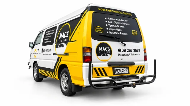 Mac’s Auto Clinic van viewed from the rear quarter, with yellow panels, black graphics and service lettering.